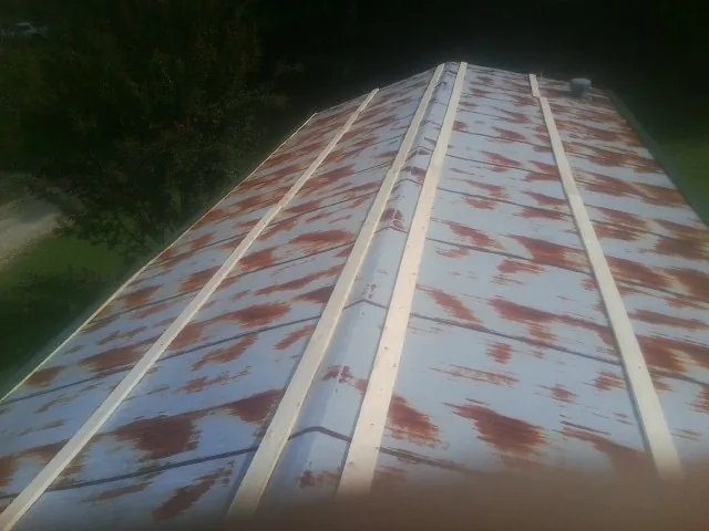 Rusted metal roof panels with new wood purlins before replacement — Storm Damage Roof Repair in Van by Roofing Brothers