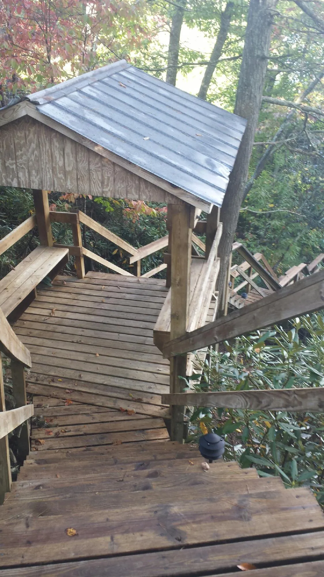 Metal roofed shelter over wooden steps on a wooded walkway — Skylight Repair & Installation work by our crew in Van