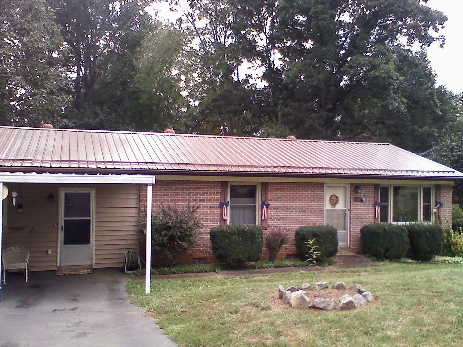 Bronze metal roof and carport on a brick ranch home — Roof Repair work by our crew in Van